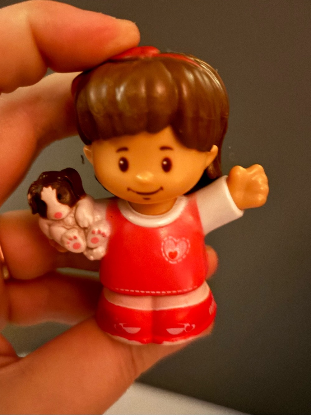 Mia figure holding a small puppy from the Fisher-Price Little People Animal Resc